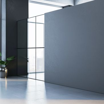 Modern interior with large windows, a glass wall, and a potted plant.