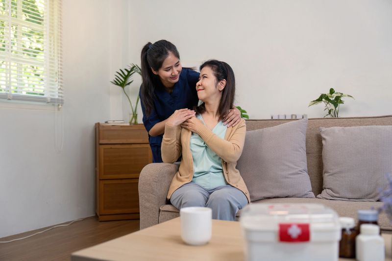 A caregiver provides emotional support to a woman in a cozy living room highlighting compassion and mental well being.