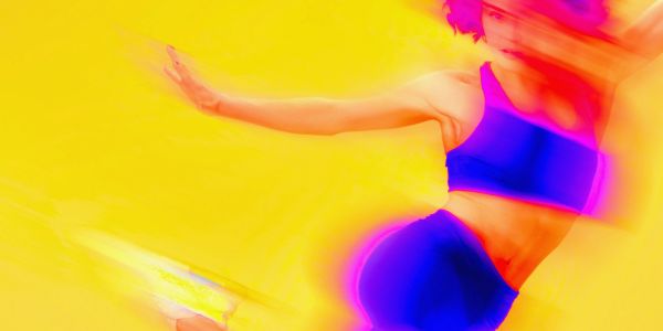 A blurred image of a person in blue sportswear against a yellow background.
