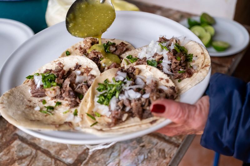 Adding salsa to head tacos