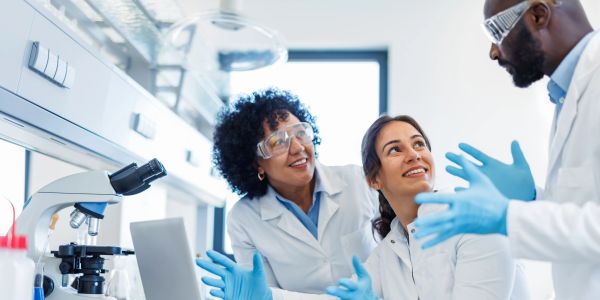 Scientists discussing in a lab with safety gear.