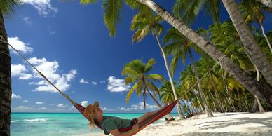 Women relaxing in a hammock on 
the beach in the Dominican Republic