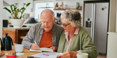 Elderly couple reviewing documents together at home.