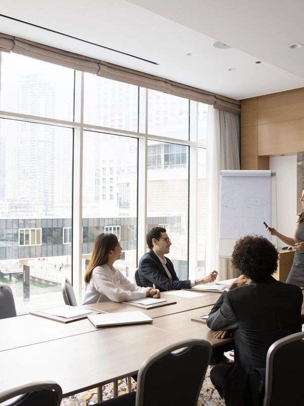A woman leading a business presentation to colleagues in a modern conference room.