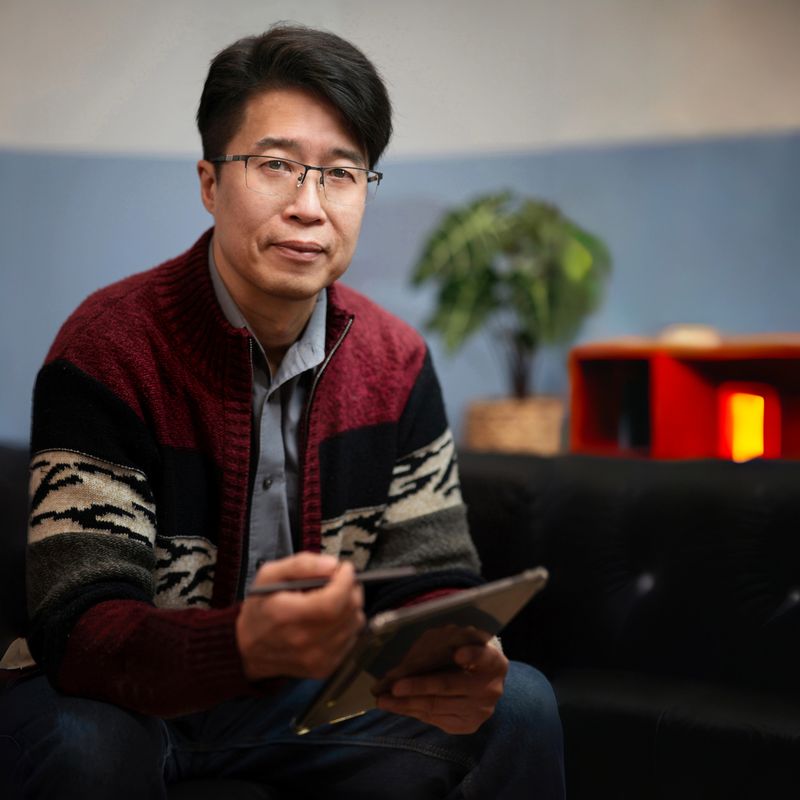 Portrait of male mental professional psychologist therapist social worker counselor businessman sitting in office with digital tablet positive looking at camera.