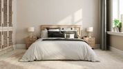 Minimalist bedroom with a cozy bed and natural light.