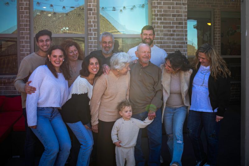 Multigenerational family, gathers for photo in back yard or prosper, tx home