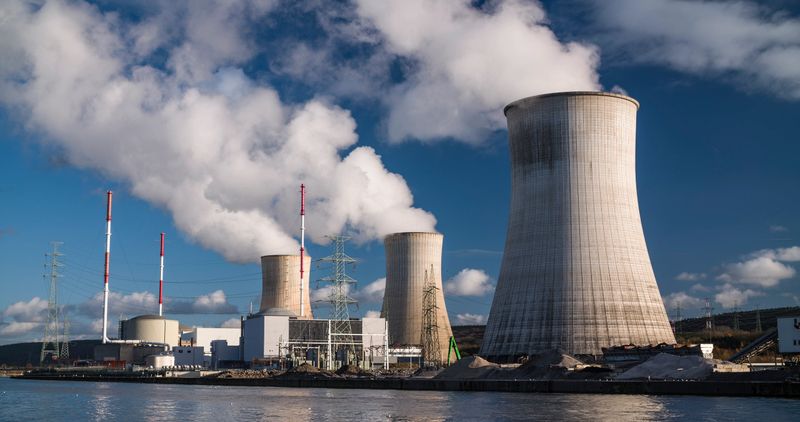 Tihange Nuclear Power Station in Belgium.  Large hyperboloid cooling towers emitting thick plumes of white steam.  Tihange in Huy, Belgium - Germany