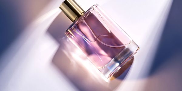Elegant perfume bottle with purple liquid and gold cap.