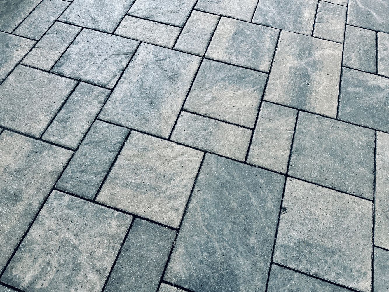 Patterned stone pavement with varied rectangular tiles.