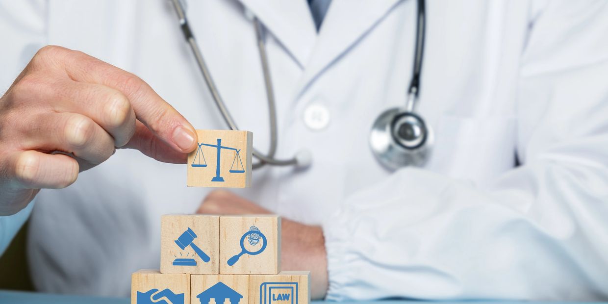 A doctor holds a wooden block with a justice scale symbol, surrounded by legal icons.