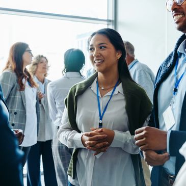 Diverse professionals networking and smiling at a conference or business event.