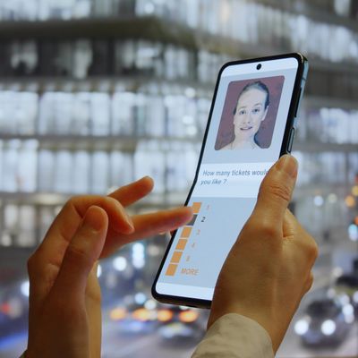 Person selecting ticket quantity on a smartphone app with a digital assistant image.