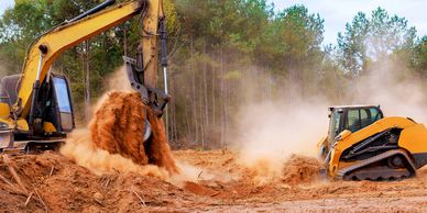 Excavator and bulldozer clearing dirt at construction site.