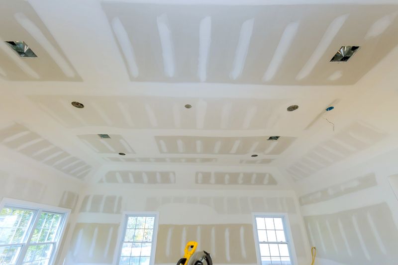 This is an interior room under renovation, with drywall partially finished, unpainted drywall on interior walls