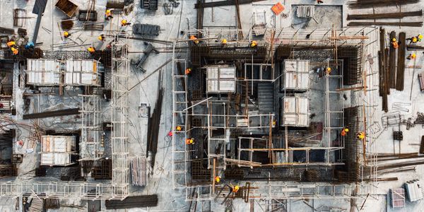 Aerial view of a busy construction site with workers and scaffolding.