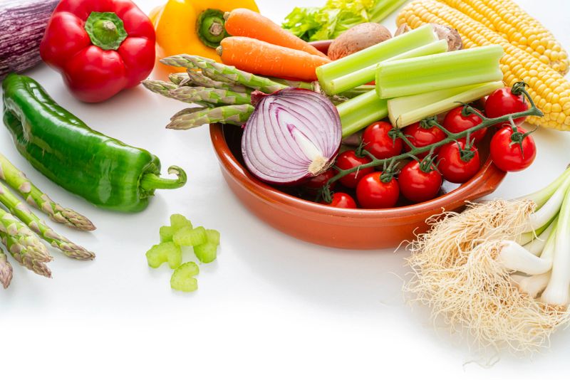 Vegan dieting. Fresh raw organic vegetables on white background