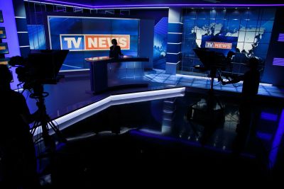 TV news studio with anchors and cameras.