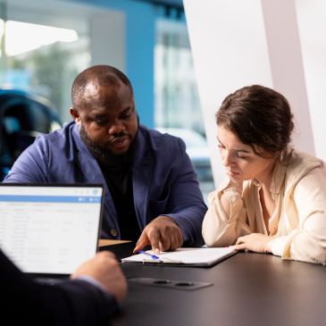 A man explains documents to a woman during a meeting.