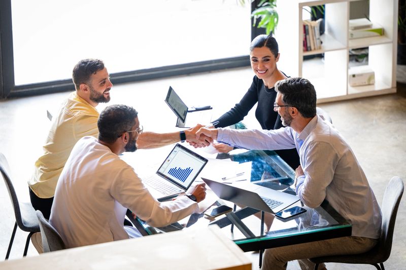 Successful business meeting between business owners and customer in modern office, handshake, agreement, new business