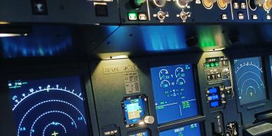 Cockpit control panel with illuminated screens and gauges.