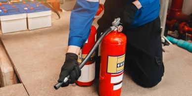 Person holding a fire extinguisher and a safety sign.