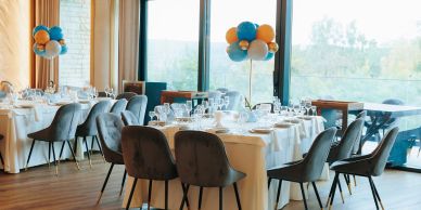 Elegant dining setup with balloons in a bright room.