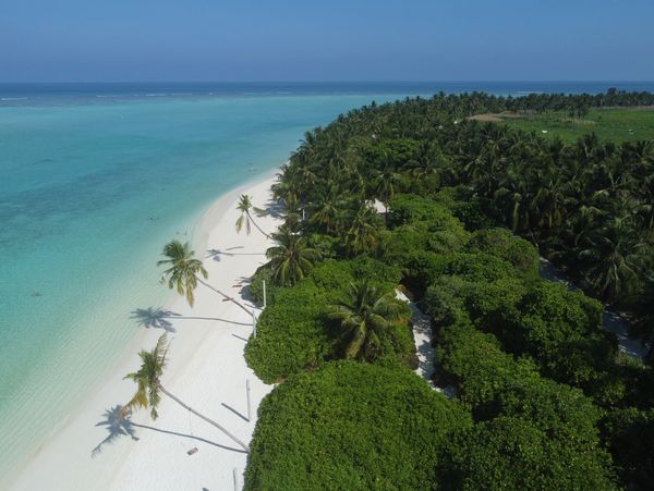 Aerial view of a tropical island with white sandy beach and turquoise water.