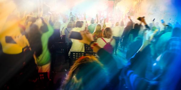 Crowd enjoying a vibrant concert with colorful lights.