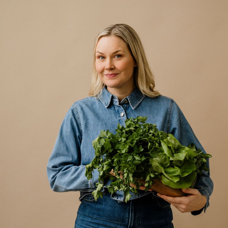Woman in studio holding fresh healthy green vegetablesWoman in her mid 40s makin ghealthy choises