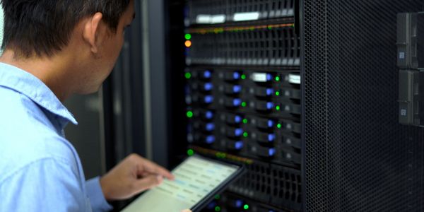 Technician using tablet in server room.