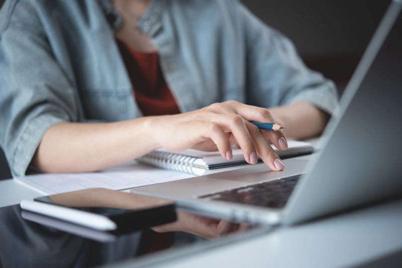Close up, woman hand typing on laptop computer keyboard. Business woman online working on laptop computer, surfing the internet, searching the information at home office, e-learning
