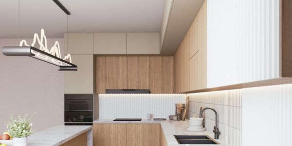 Modern kitchen with wood cabinets and marble countertops.