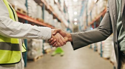 Acuerdo comercial entre representantes en un almacén de distribución.