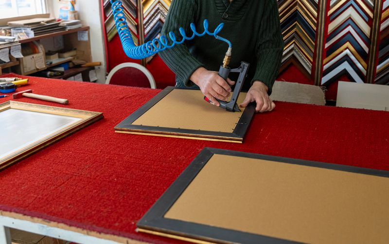 Man making photo frames working in workshop