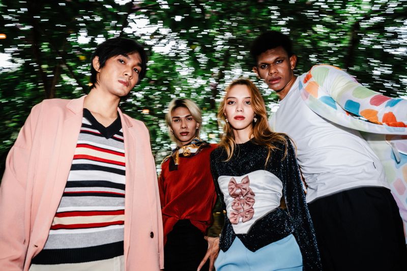 Stylish group portrait featuring bold colors and creative fashion statements, capturing individuality and group synergy in a vibrant outdoor environment.