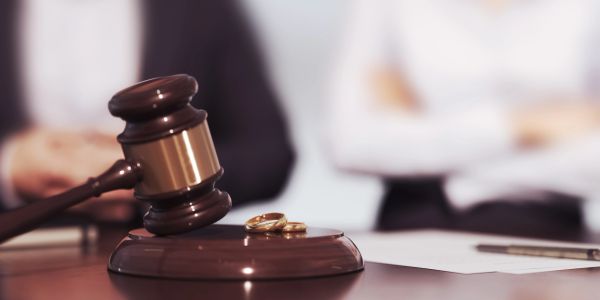 Judge's gavel with wedding rings symbolizing divorce.