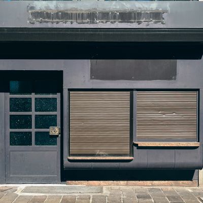 Closed storefront with dark shutters and door.