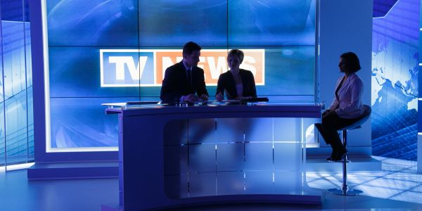 Trois personnes en plateau TV.