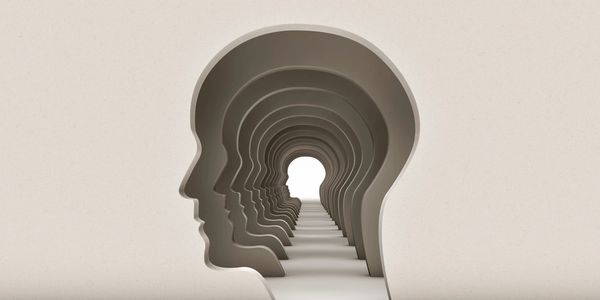 Multiple human head silhouettes forming a tunnel leading to a lighted head shape.