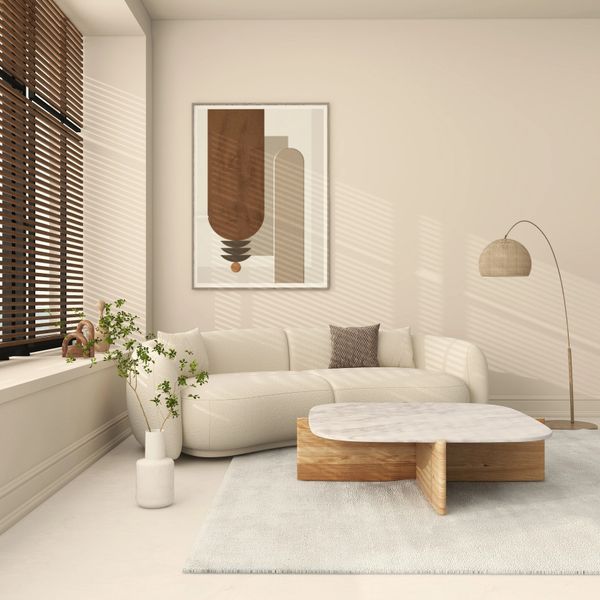 Minimalist beige living room with curved sofa and wooden marble coffee table.