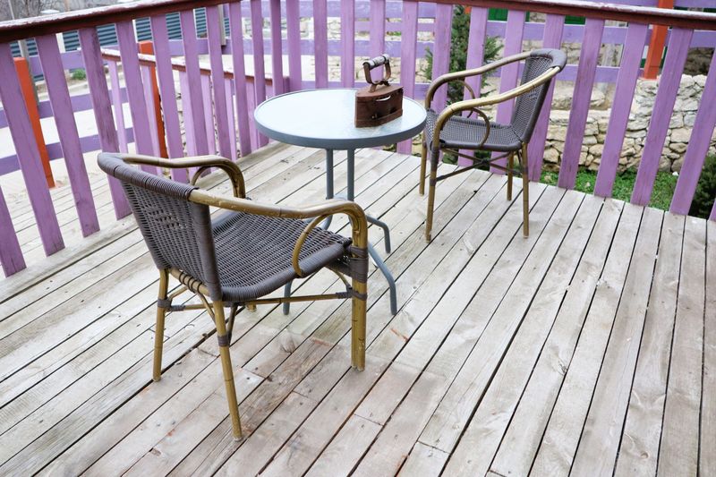 An inviting patio area, beautifully designed with two comfortable chairs and a stylish table, perfect for relaxation