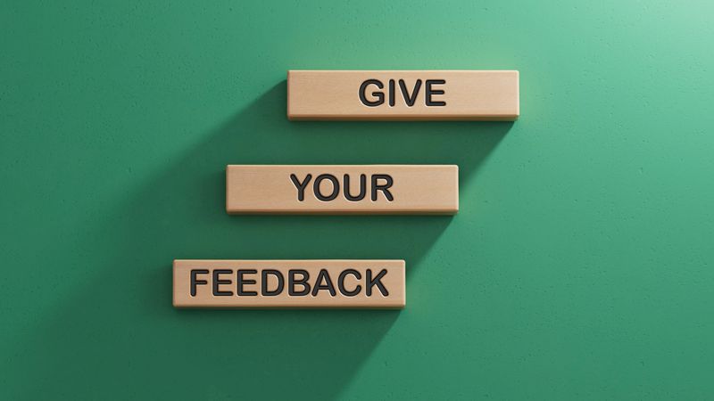 Feedback symbol. Concept word Give your feedback on wooden blocks.Business and Ask for feedback concept. Copy space.3D rendering on green background.