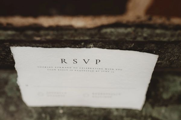 Close-up of an RSVP card on a textured surface.