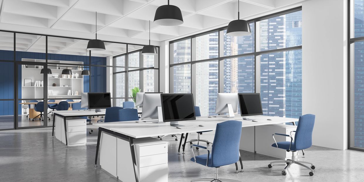 Modern office space with blue chairs and large windows overlooking city buildings.