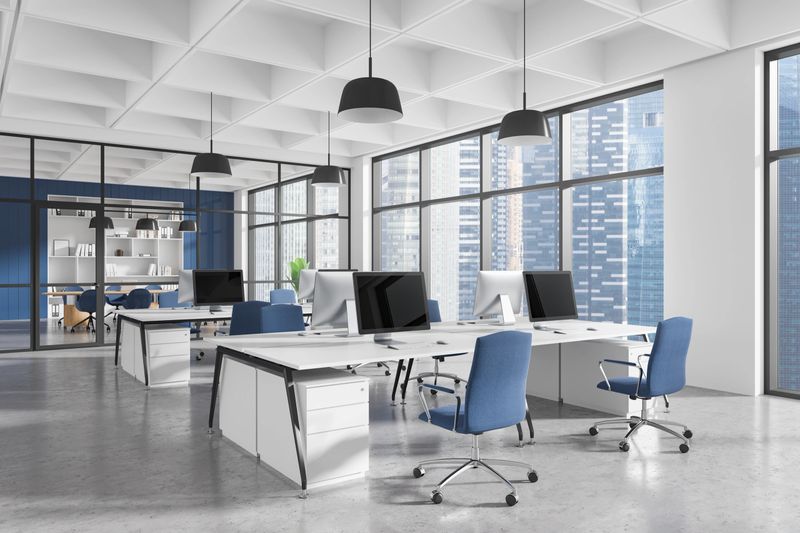 Contemporary office interior with ergonomic furniture, blue chairs, desks, and computers in a spacious area with large windows. Concept of workspace design. 3D Rendering.