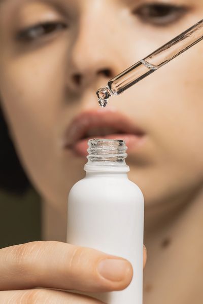 Woman applying a medical-grade skincare serum with a dropper