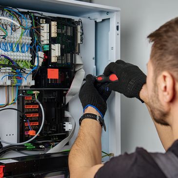 Technician repairing electronic control panel.