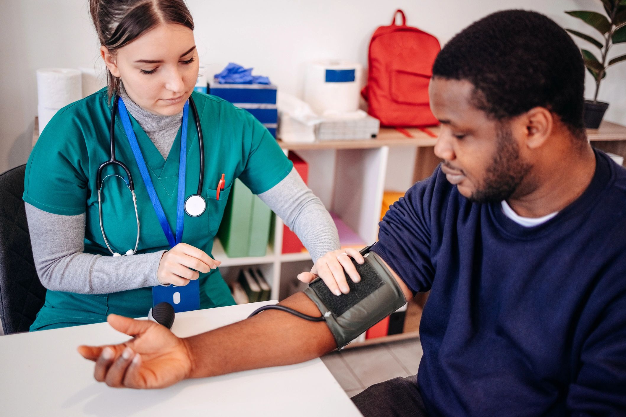 A nurse checking a man's blood pressure at a community health screening