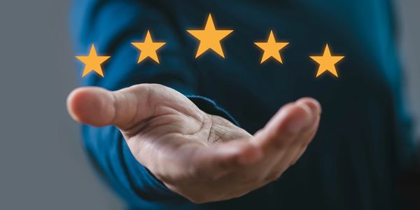Hand presenting five glowing stars, symbolizing top quality or rating.
